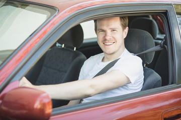Junger Mann sitzt im Auto