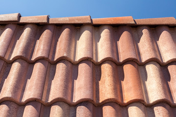 Red roof tile pattern over blue sky