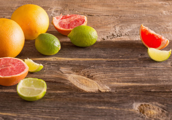 Set of sliced citrus fruits over wooden background