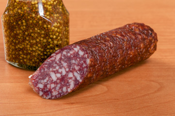 Salami for Breakfast with pepper on a wooden table