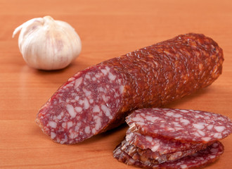 Salami for Breakfast with pepper on a wooden table