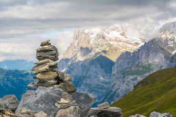 Fototapeta na wymiar Small cairn with snow alpine mountains at background