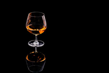 A glass of brandy on a black background