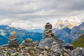 Small cairn with snow alpine mountains at background