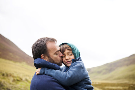 UK, Bala, father and son hugging each other
