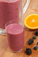Mixed Berry Frothy with orange, blackberries and blueberries in a clear glass with blender