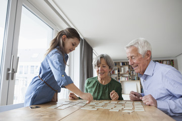 Little girl playing memory with her grandparents at home