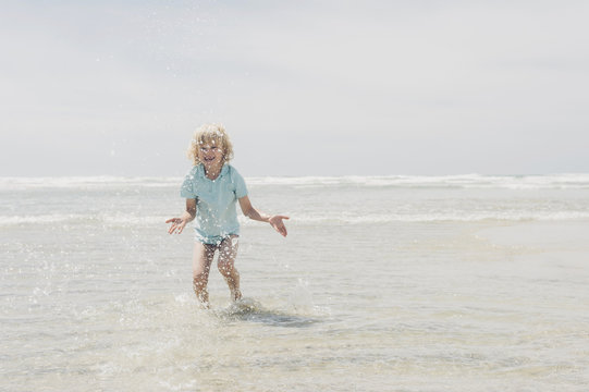 France, Brittany, Finistere, Pointe de la Torche, boy playing in water