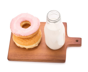 Milk bottle and donut on white background