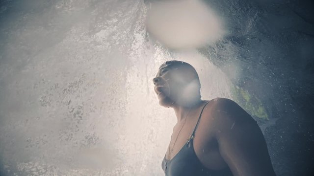 Happy woman behind waterfall in Panama. Slow motion