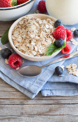 Rolled oats in a bowl with berries and milk