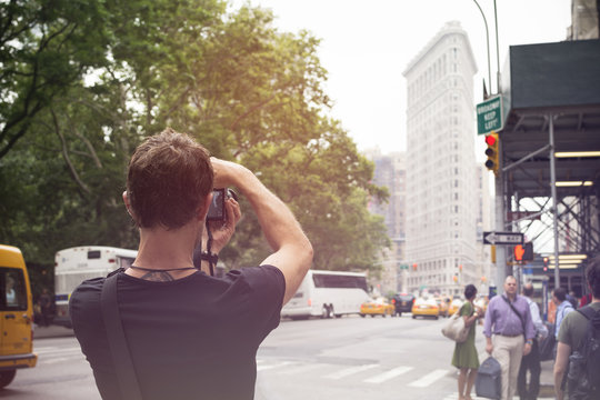 USA, New York City, Tourist taking pictures of Flatiron Building