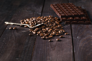 Chocolate and coffee on dark wooden background