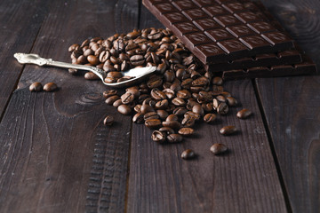 Chocolate and coffee on dark wooden background