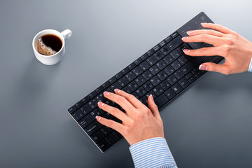 Woman's hands on wireless keyboard.