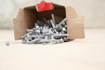 carton box ful of screws with wall plugs