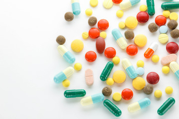 Colorful many tablets ,pills and pill capsules on white backgrou