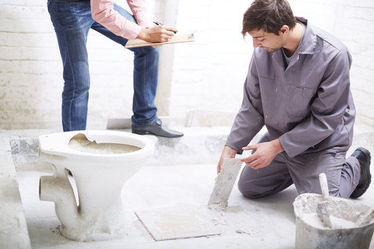 Construction worker with tiling trowel