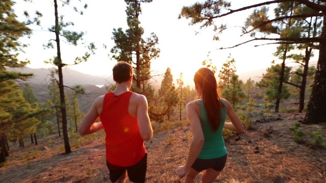 Running Health and fitness. Runners on run training during fitness workout outside in mountain forest at sunset. People jogging together living healthy active lifestyle outside. Woman and man. 2 clips