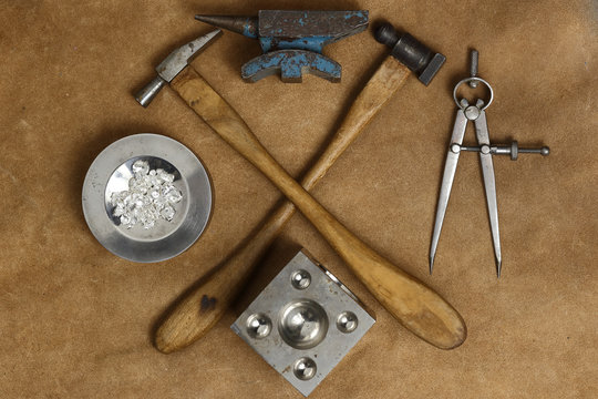 Tools of jewellery. Jewelry workplace on leather background. Hammers, anvil. Top view.