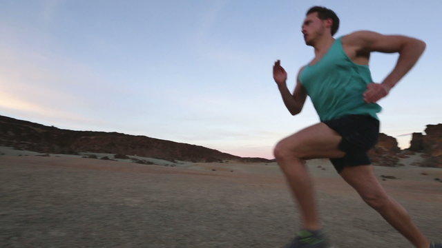 Running runner  man sprinting fast. Male runner sprinter at high speed during high intensity interval training workout outdoors in desert mountain nature landscape. Healthy active lifestyle people.