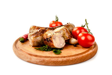 fried pork sausages on a barbecue on a wooden plate with cherry tomatoes and hot peppers