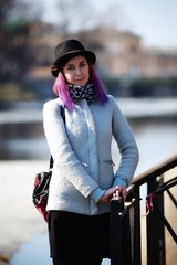 Stylish, young and beautiful girl with color hair poses on streets of St. Petersburg
