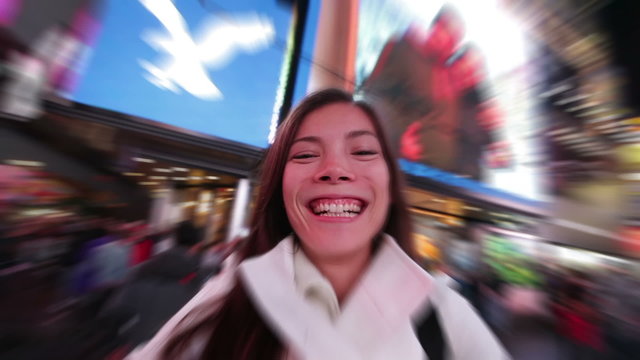 Selfie happy woman tourist taking selfportrait video having fun in New York City, Manhattan, Times Square. Girl traveler taking selfie joyful smiling. Multiethnic Asian Caucasian woman in her 20s.