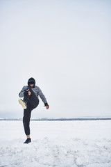 Fototapeta na wymiar Athlete warming up in the winter on the nature