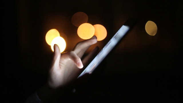 Woman finger touching tablet touchscreen at night time. Close upv
