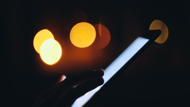 Woman finger touching tablet touchscreen at night time. Close upv
