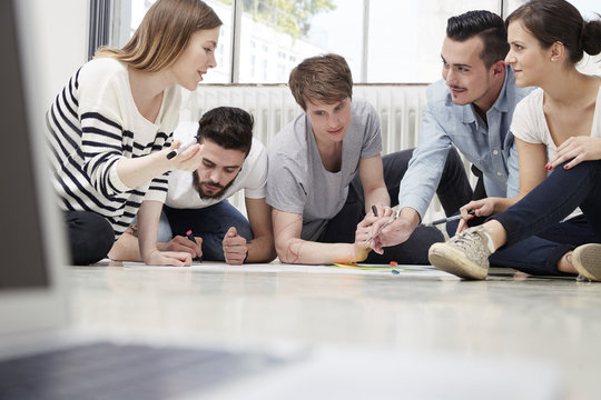Group of creative professionals working on floor