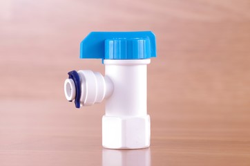 Plastic tap on wooden background. Plastic tap from Reverse Osmosis water filter system.