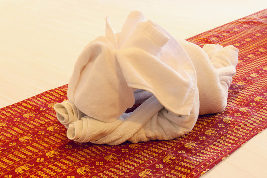 white towel elephant,red mat on white cloth background.