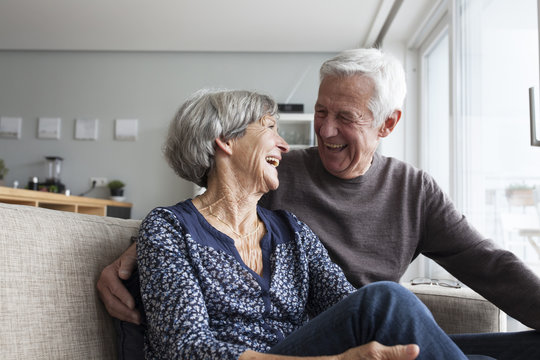 Senior couple sitting on couch and laughing