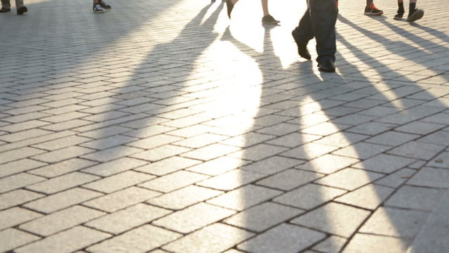 Pedestrian commuters - shadows of people walking in city. Business people feet walking home from work. Berlin, Germany.