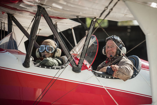 Germany, Dierdorf, Grandfather and grandson sitting on old biplane
