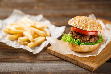 Homemade hamburgers and french fries on wooden table