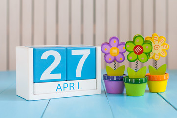 April 27th. Image of april 27 wooden color calendar on white background with flower. Spring day, empty space for text