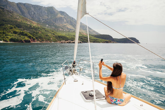 girl yachting with smartphone photograph cruise