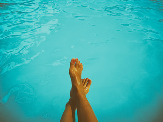 Young Girl Relaxing Her Feet At Swimming Pool