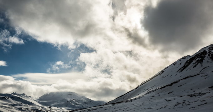 Clouds rolling along mountains timelapse