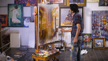 Inspiration. Colorful professional artist paints with oil. Workshop