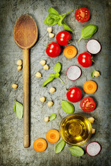 Wooden spoon and fresh ingredients on old background