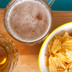 potato chips and a mug of beer on the table; view from above
