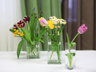 Bouquets of fresh flowers on white table