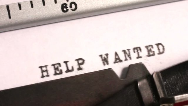 Typing 'Help Wanted' as an advertisement or offer for a job on an old manual typewriter.