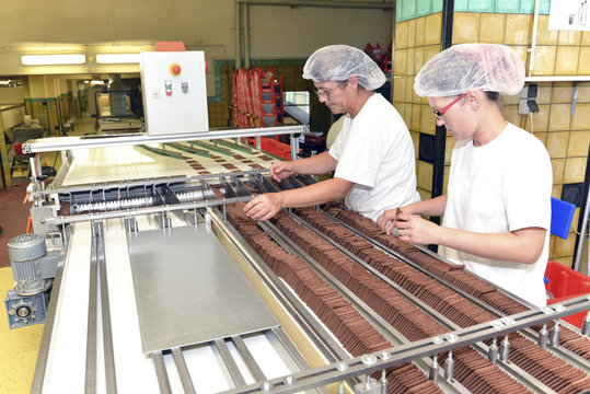 Germany, Saxony-Anhalt, two women working at production line in a baking factory