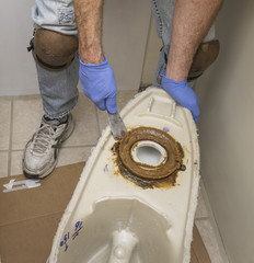 Plumber showing wax ring on toilet