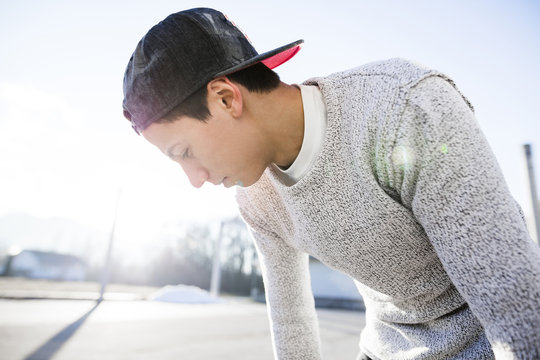 Young man wearing baseball cap in backlight